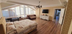 a bedroom with a bed and a chair and a television at Airport apartament in Sîngera