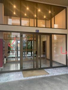 an entrance to a building with glass doors at LA PERLE DU THIOU - Charmant T3 au Centre d'Annecy avec Parking Privé in Annecy