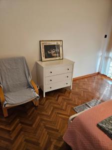 Un dormitorio con un tocador y una silla con una foto. en Singolo Mini Apartamento en Padova