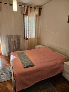 - une chambre avec un lit et une couverture orange dans l'établissement Singolo Mini Apartamento, à Padoue