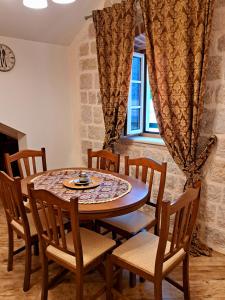 uma sala de jantar com uma mesa e cadeiras e uma janela em Apartment Radimiri em Kotor