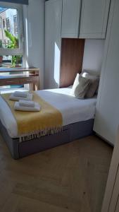 a bedroom with a bed with two towels on it at Chelsea Pad by condokeeper in London