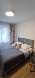 a large bed in a bedroom with a window at Zakręt Solina BALIA RELAKS 537-791-246 in Solina