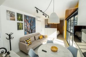 un soggiorno con divano e tavolo di Belíssimo e moderno studio para casais STU309 a Florianópolis