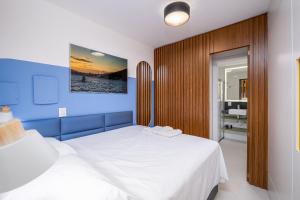 een slaapkamer met 2 witte bedden en een blauwe muur bij Belíssimo e moderno studio para casais STU309 in Florianópolis