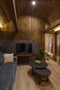 ein Wohnzimmer mit einem Sofa und einem Tisch in der Unterkunft Wood cabin Kolasin in Kolašin