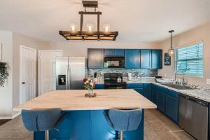 a kitchen with blue cabinets and a wooden counter top at The Patriot House - Pet Friendly plus Hot Tub and Fire Pit in San Antonio