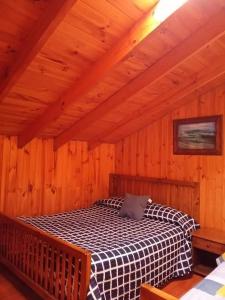 1 dormitorio con 1 cama en una cabaña de madera en OCEANO HOSTEL, en Pichilemu