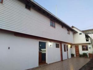 a large white building with a garage at OCEANO HOSTEL in Pichilemu
