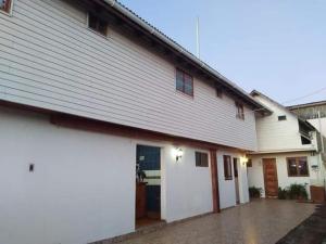 een groot wit gebouw met een garage bij OCEANO HOSTEL in Pichilemu +4 foto's