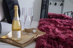 a bottle of champagne and two wine glasses on a table at Spacious and modern family apartment, central and within walking distance to local amenities in Abergele