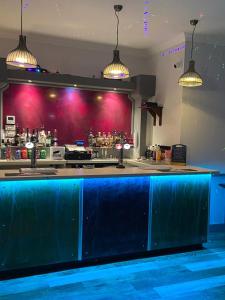 a blue bar in a restaurant with pink walls at The Ivy in Lincolnshire