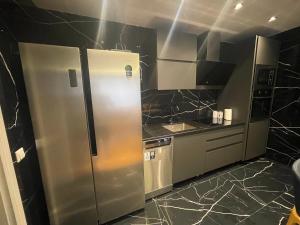 una cocina con nevera y electrodomésticos de acero inoxidable en Sonny’s Penthouse en Gnjilane