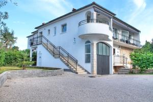 een wit huis met een trap en een balkon bij Apartments Nebuloza in Rovinj