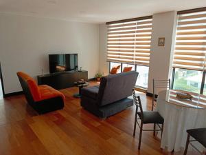 a living room with a couch and chairs and a television at Espectacular Dpto. 2D(cala coto) in La Paz