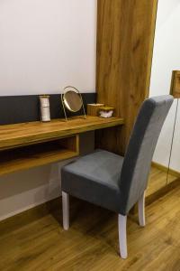 a chair sitting next to a desk with a mirror at Rubikon apartmani in Dušanovac (historical)