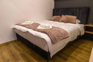 1 dormitorio con 1 cama con 2 toallas en Rubikon apartmani, en Dušanovac (historical)