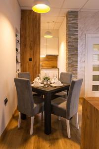 a dining room with a black table and chairs at Rubikon apartmani in Dušanovac (historical)