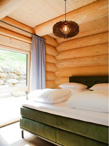 ein Schlafzimmer mit einem Bett in einer Holzwand in der Unterkunft Ahütten in Bodenmais