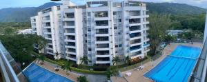 a large white apartment building with a swimming pool at Apartamento en Condominio in San Jerónimo