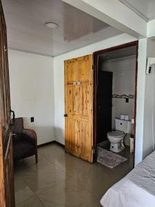 baño con puerta de madera y aseo en Hotel Liah's, en Tortuguero