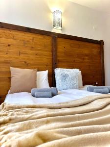 a large bed with a wooden headboard in a room at Red House Family Hotel in Bansko