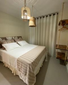 a bedroom with a bed and two chandeliers at Volantes do Sertão - Ecoville in Piranhas