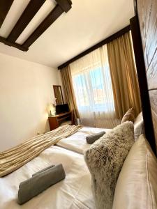 a bedroom with two beds and a window at Red House Family Hotel in Bansko