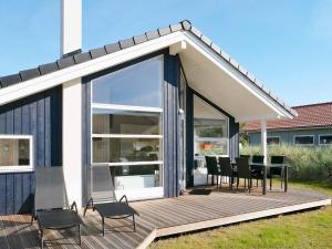 グローセンブローデにある6 person holiday home in Gro enbrodeの家の上にテーブルと椅子付きのデッキ