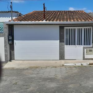 a pair of white garage doors on a house at Recanto do Centro in Cananéia