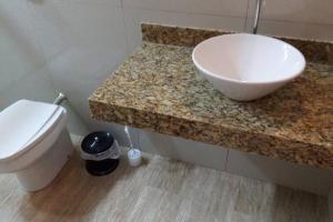 - une salle de bains avec un bol blanc sur un comptoir à côté des toilettes dans l'établissement Pirassununga, SP - Casa 3 suítes em condomínio RURAL - 06 hóspedes Confortáveis, à Pirassununga 44 autres photos