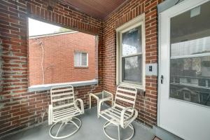 - deux chaises et une table sur une terrasse couverte à côté d'un mur en briques dans l'établissement Pet-Friendly Pittsburgh Home about 9 Mi to Downtown!, à Pittsburgh