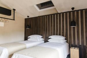 dwa łóżka siedzące obok siebie w pokoju w obiekcie TerraSense Mountain Charm Retreat & Farm w mieście Videmonte