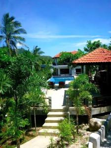 a house with a staircase in front of a yard at Viking House Villa Deluxe in Ko Tao