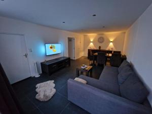 uma sala de estar com um sofá e uma sala de jantar em Happy Home em Kerkrade