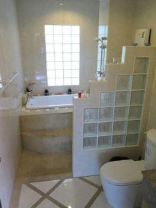 a bathroom with a tub and a toilet and a sink at Viking House Villa Deluxe in Koh Tao