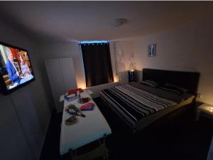 een kleine slaapkamer met een bed en een televisie bij Happy Home in Kerkrade