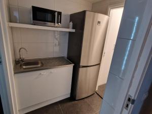 een kleine keuken met een koelkast en een magnetron bij Happy Home in Kerkrade
