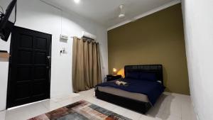 a bedroom with a bed with a dog laying on it at Rerama Room Stay Langkawi in Pantai Cenang