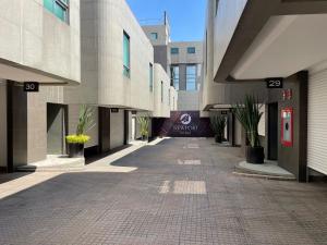 uma passagem vazia entre dois edifícios numa cidade em NewPort Love Hotel em Cidade do México