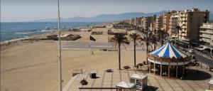 einen Strand mit einem blauen und weißen Zelt und einem Strand in der Unterkunft Mobil-home 5 personnes dans camping Mar Estang 4 étoiles avec accès à la plage in Canet-en-Roussillon