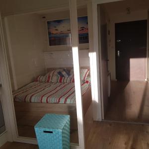 Dormitorio pequeño con cama y espejo en Magnifique studio double cabine en Le Touquet-Paris-Plage