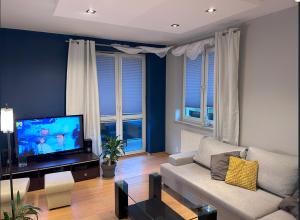 a living room with a couch and a flat screen tv at Apartament w Wesołej in Warsaw