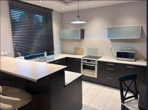 a kitchen with brown cabinets and a counter top at Apartament w Wesołej in Warsaw