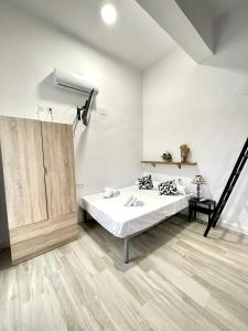 a white room with a bed and a staircase at Apartamento Sotos 1 in Córdoba