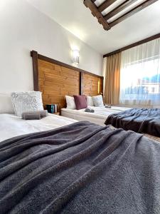 a hotel room with two beds and a window at Red House Family house in Bansko +46 photos