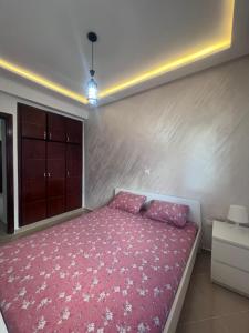 1 dormitorio con 1 cama con manta rosa en Luxury Center Town Apartment, en Kenitra