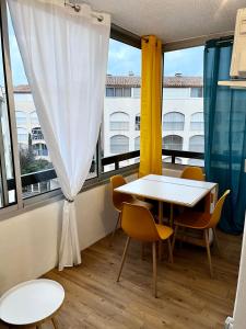 a table and chairs in a room with a window at Studio Chaleureux au Cap d’Agde in Cap d'Agde +23 photos