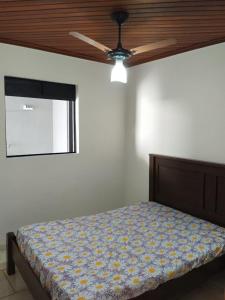 um quarto com uma cama e uma ventoinha de tecto em Glenda temporada em Olímpia