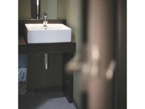 ein Badezimmer mit einem weißen Waschbecken und einem Spiegel in der Unterkunft Sakishima Cosmo Tower Hotel - Vacation STAY 01080v in Osaka